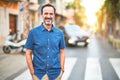 Middle age handsome man standing on the street smiling