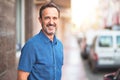 Middle age handsome man standing on the street smiling