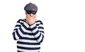 Middle age handsome man wearing burglar mask shocked covering mouth with hands for mistake