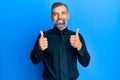 Middle age handsome man wearing business shirt and tie success sign doing positive gesture with hand, thumbs up smiling and happy Royalty Free Stock Photo