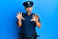 Middle age handsome man wearing police uniform smiling funny doing claw gesture as cat, aggressive and sexy expression Royalty Free Stock Photo