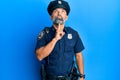 Middle age handsome man wearing police uniform thinking concentrated about doubt with finger on chin and looking up wondering