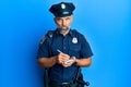 Middle age handsome man wearing police uniform writing traffic fine skeptic and nervous, frowning upset because of problem