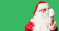 Middle age handsome man wearing Santa Claus costume and beard standing Doing Italian gesture with hand and fingers confident Royalty Free Stock Photo