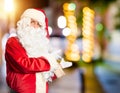 Middle age handsome man wearing Santa Claus costume and beard standing Inviting to enter smiling natural with open hand Royalty Free Stock Photo
