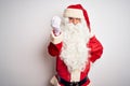 Middle age handsome man wearing Santa costume standing over isolated white background Doing Italian gesture with hand and fingers Royalty Free Stock Photo