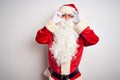 Middle age handsome man wearing Santa costume standing over isolated white background Trying to open eyes with fingers, sleepy and Royalty Free Stock Photo
