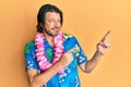 Middle age handsome man wearing summer shirt and hawaiian lei smiling and looking at the camera pointing with two hands and Royalty Free Stock Photo