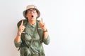 Middle age hiker woman wearing backpack canteen hat glasses over isolated white background amazed and surprised looking up and Royalty Free Stock Photo