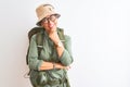 Middle age hiker woman wearing backpack canteen hat glasses over isolated white background looking confident at the camera smiling Royalty Free Stock Photo