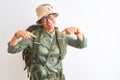 Middle age hiker woman wearing backpack canteen hat glasses over isolated white background looking confident with smile on face, Royalty Free Stock Photo