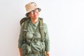 Middle age hiker woman wearing backpack canteen hat glasses over isolated white background smiling looking to the side and staring Royalty Free Stock Photo