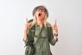 Middle age hiker woman wearing backpack hat canteen glasses over isolated white background amazed and surprised looking up and Royalty Free Stock Photo