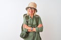 Middle age hiker woman wearing backpack hat canteen glasses over isolated white background happy face smiling with crossed arms Royalty Free Stock Photo