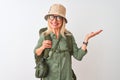 Middle age hiker woman wearing backpack hat canteen glasses over isolated white background smiling cheerful presenting and Royalty Free Stock Photo