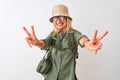 Middle age hiker woman wearing backpack hat canteen glasses over isolated white background smiling looking to the camera showing Royalty Free Stock Photo