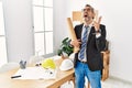 Middle age hispanic business man holding paper blueprints crazy and mad shouting and yelling with aggressive expression and arms Royalty Free Stock Photo