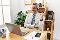 Middle age hispanic business man working at the office wearing operator headset with a big smile on face, pointing with hand and Royalty Free Stock Photo