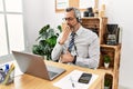Middle age hispanic business man working at the office wearing operator headset bored yawning tired covering mouth with hand Royalty Free Stock Photo