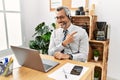 Middle age hispanic business man working at the office wearing operator headset cheerful with a smile of face pointing with hand Royalty Free Stock Photo