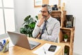 Middle age hispanic business man working at the office wearing operator headset looking confident at the camera smiling with Royalty Free Stock Photo