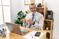Middle age hispanic business man working at the office wearing operator headset pointing fingers to camera with happy and funny Royalty Free Stock Photo
