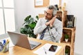 Middle age hispanic business man working at the office wearing operator headset sleeping tired dreaming and posing with hands Royalty Free Stock Photo