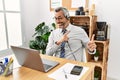 Middle age hispanic business man working at the office wearing operator headset smiling and looking at the camera pointing with Royalty Free Stock Photo