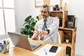 Middle age hispanic business man working at the office wearing operator headset smiling looking to the camera showing fingers Royalty Free Stock Photo