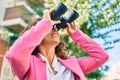 Middle age hispanic businesswoman smiling happy looking for new opportunity using binoculars at the city Royalty Free Stock Photo