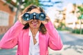 Middle age hispanic businesswoman smiling happy looking for new opportunity using binoculars at the city Royalty Free Stock Photo