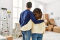 Middle age hispanic couple on back view hugging and standing at new home Royalty Free Stock Photo