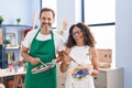 Middle age hispanic couple painting at art studio winking looking at the camera with sexy expression, cheerful and happy face Royalty Free Stock Photo