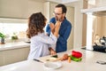 Middle age hispanic couple smiling confident eating zucchini at kitchen Royalty Free Stock Photo