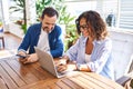 Middle age hispanic couple smiling confident using laptop and smartphone at terrace Royalty Free Stock Photo