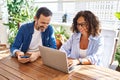 Middle age hispanic couple smiling confident using laptop and smartphone at terrace Royalty Free Stock Photo