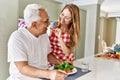 Middle age hispanic couple smiling happy eating beef with salad at the kitchen Royalty Free Stock Photo