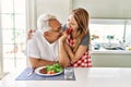 Middle age hispanic couple smiling happy eating beef with salad at the kitchen Royalty Free Stock Photo