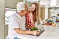 Middle age hispanic couple smiling happy eating beef with salad at the kitchen Royalty Free Stock Photo