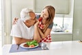 Middle age hispanic couple smiling happy eating beef with salad at the kitchen Royalty Free Stock Photo