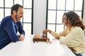 Middle age hispanic couple smiling happy sitting on the table playing chess at home Royalty Free Stock Photo