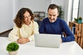 Middle age hispanic couple smiling happy using laptop at home Royalty Free Stock Photo