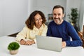 Middle age hispanic couple smiling happy using laptop at home Royalty Free Stock Photo