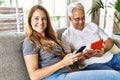 Middle age hispanic couple smiling happy using tablet and smartphone at home Royalty Free Stock Photo