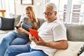 Middle age hispanic couple smiling happy using tablet and smartphone at home Royalty Free Stock Photo