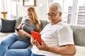 Middle age hispanic couple smiling happy using tablet and smartphone at home Royalty Free Stock Photo