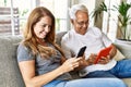 Middle age hispanic couple smiling happy using tablet and smartphone at home Royalty Free Stock Photo