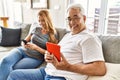 Middle age hispanic couple smiling happy using tablet and smartphone at home Royalty Free Stock Photo