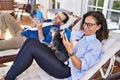 Middle age hispanic couple using smartphone and touchpad lying on hammock with dog at terrace Royalty Free Stock Photo