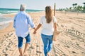 Middle age hispanic couple walking at the beach on back view Royalty Free Stock Photo